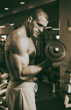 Genç adam spor salonunda antrenman yapıyor.