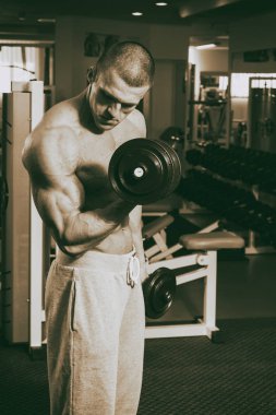 Genç adam spor salonunda antrenman yapıyor.