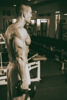 Genç adam spor salonunda antrenman yapıyor.