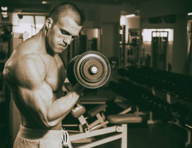 Genç adam spor salonunda antrenman yapıyor.
