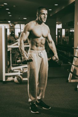 Genç adam spor salonunda antrenman yapıyor.