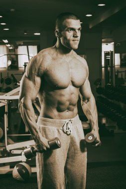 Genç adam spor salonunda antrenman yapıyor.