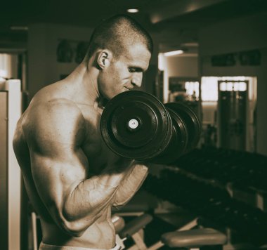 Genç adam spor salonunda antrenman yapıyor.