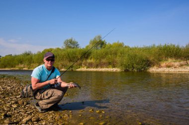Genç balık adam. Dağ Nehri üzerinde Balık tutma. Alabalık balıkçılık.