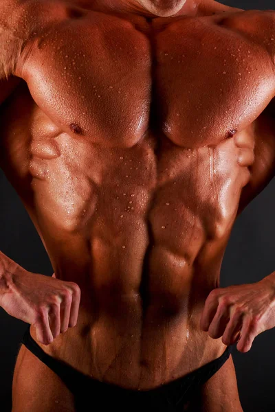 Cuerpo masculino muscular sobre un fondo negro — Foto de Stock