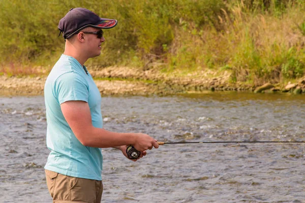 Jonge man visserij. Vissen op de rivier van de berg. Vissen op forel. — Stockfoto