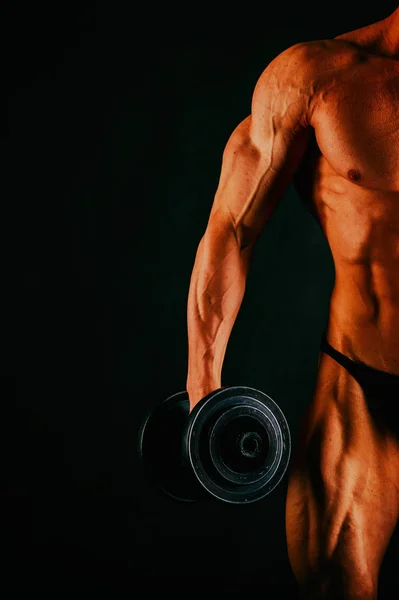 Joven musculoso culturista posando sobre fondo negro —  Fotos de Stock