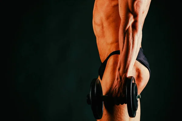 검은 배경 위에 포즈를 취하는 젊은 근육질 보디빌더 — 스톡 사진