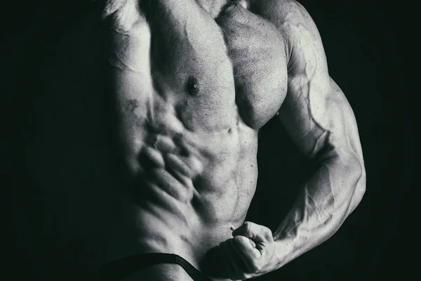 Cuerpo masculino muscular sobre un fondo negro — Foto de Stock