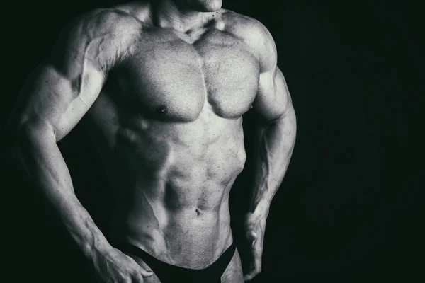 М'язисте чоловіче тіло на чорному тлі — стокове фото