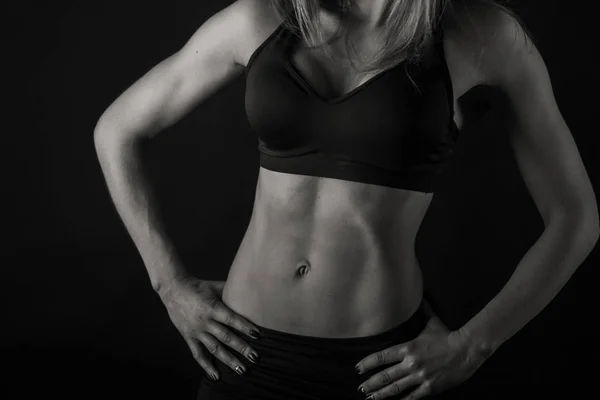 Atractiva mujer fitness sobre un fondo negro — Foto de Stock