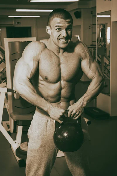 El hombre está ocupado con pesas en el gimnasio. —  Fotos de Stock