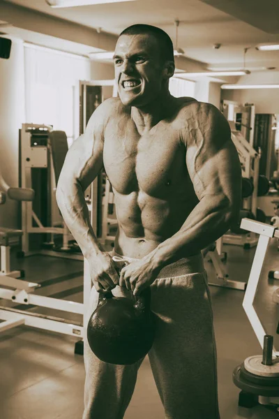 Der Mann ist im Fitnessstudio mit Gewichten beschäftigt — Stockfoto