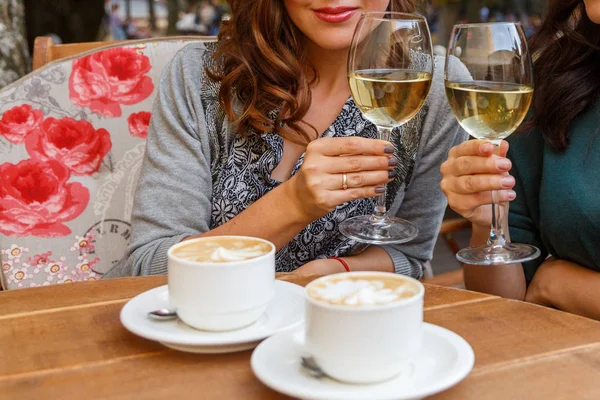 在一家咖啡馆喝红酒和咖啡的女人 — 图库照片