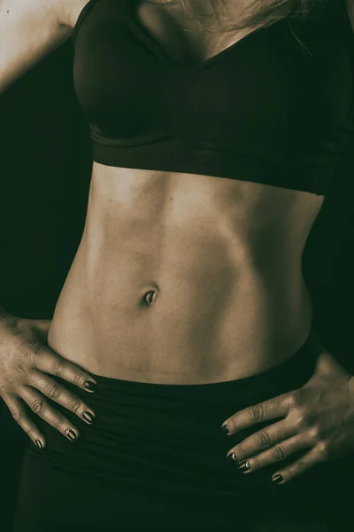 Fitness cuerpo de mujer sobre un fondo negro — Foto de Stock