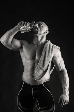 Siyah bir arka plan üzerinde poz acemi vücut geliştirmeci