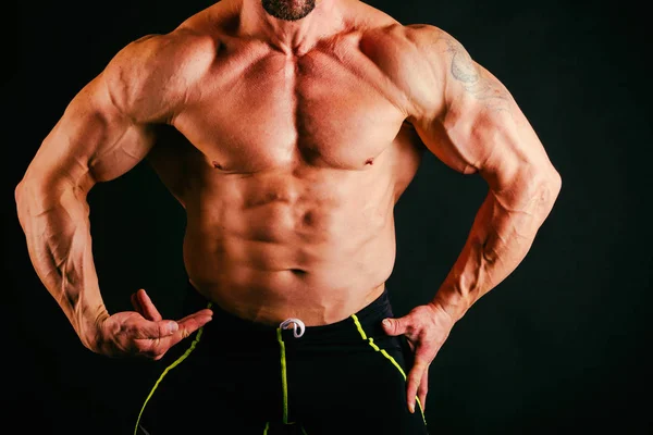 Trained muscular man on a black background — Stock Photo, Image