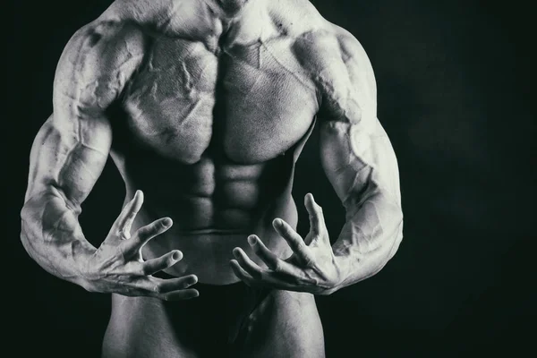 Músculos masculinos em um fundo preto — Fotografia de Stock