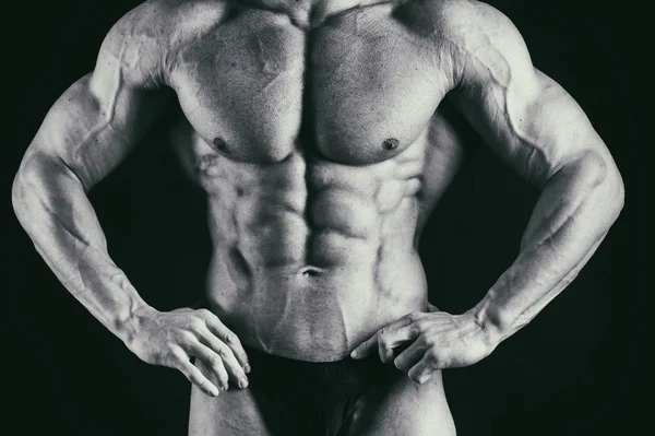 Músculos de los hombres sobre un fondo negro — Foto de Stock
