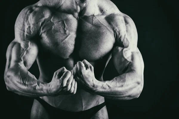 Men's muscles on a black background — Stock Photo, Image