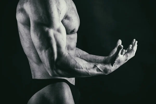 Men's muscles on a black background — Stock Photo, Image