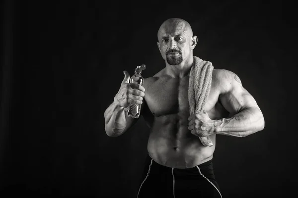 Novice bodybuilder posing on a black background — Stock fotografie