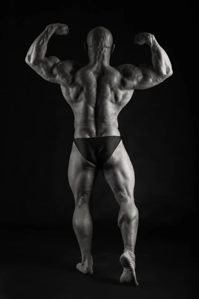 Novice bodybuilder posing on a black background — Stock Photo, Image