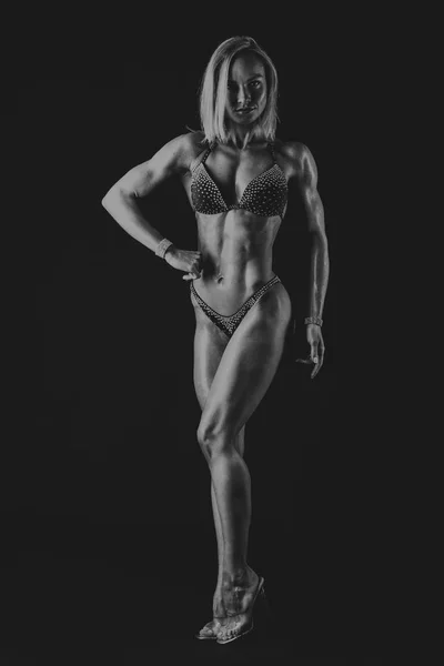 Elegante allenamento, donna muscolosa su sfondo nero — Foto Stock