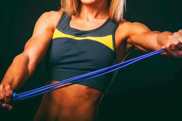 Elegant training, muscular woman on a black background — Stock Photo, Image