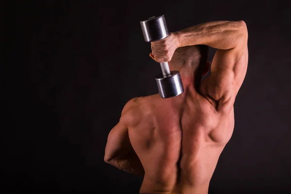 Hombre con mancuernas sobre fondo negro — Foto de Stock