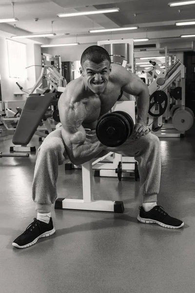 Homme avec un haltère dans un club de fitness — Photo