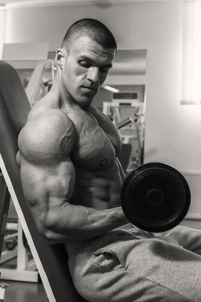 Man with a dumbbell in fitness club — Stock Photo, Image