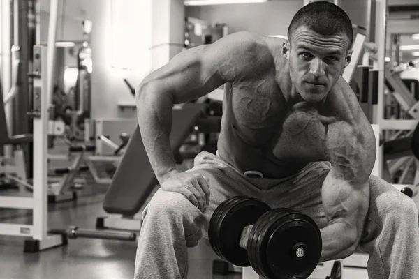 Homme avec un haltère dans un club de fitness — Photo