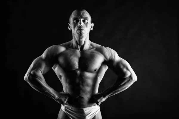 Männlicher Bodybuilder auf schwarzem Hintergrund — Stockfoto