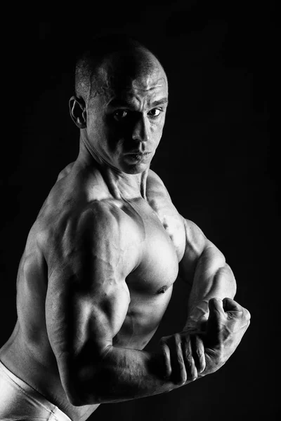 Männlicher Bodybuilder auf schwarzem Hintergrund — Stockfoto