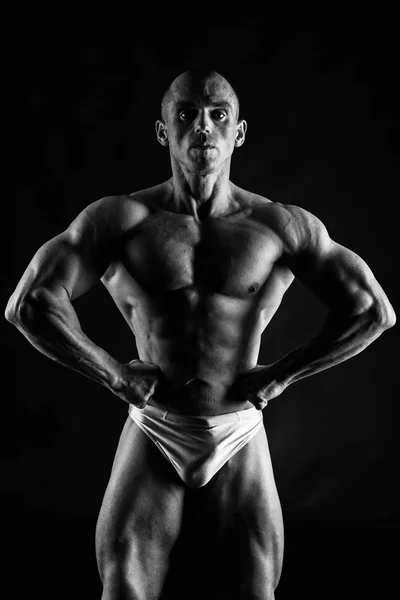 Mannelijke bodybuilder op een zwarte achtergrond — Stockfoto