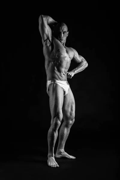 Männlicher Bodybuilder auf schwarzem Hintergrund — Stockfoto