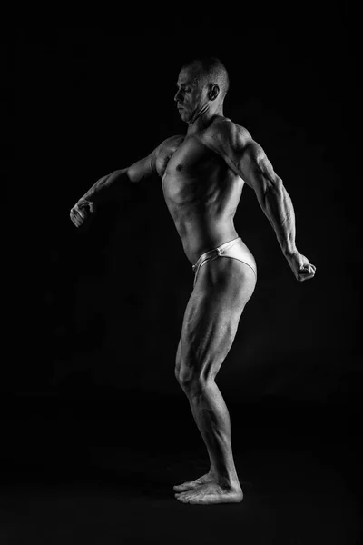 Siyah bir arka plan üzerinde erkek vücut geliştirmeci — Stok fotoğraf