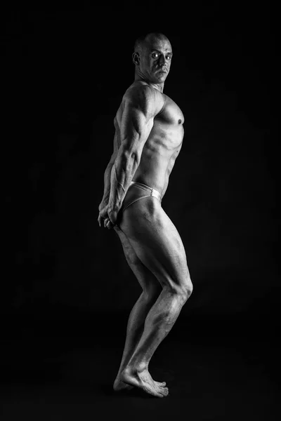 Männlicher Bodybuilder auf schwarzem Hintergrund — Stockfoto