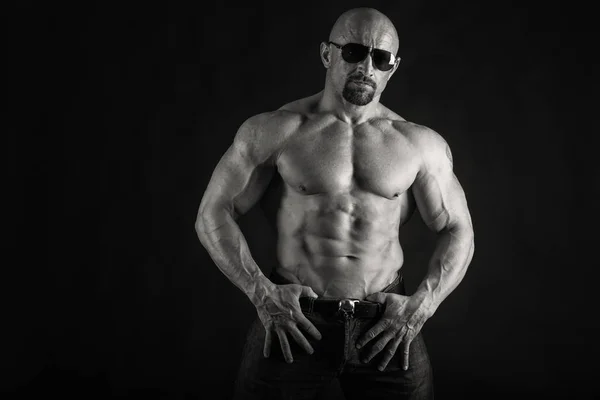 Powerful bodybuilder on a black background — Stock Photo, Image