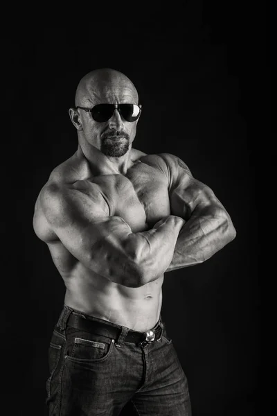 Kraftvoller Bodybuilder auf schwarzem Hintergrund — Stockfoto