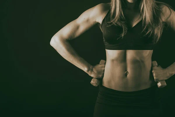 Kroppen av en vacker atletisk flicka på svart — Stockfoto