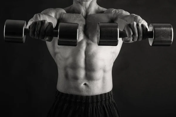 Corpo masculino muscular em um fundo preto — Fotografia de Stock
