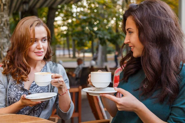 Девушка пьет кофе в кафе на улице — стоковое фото
