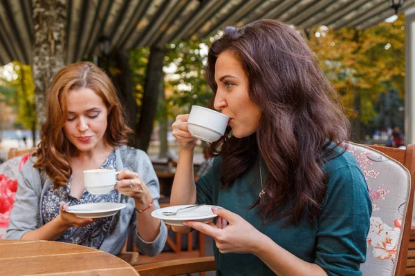 Dívka pití kávy v kavárně na ulici — Stock fotografie