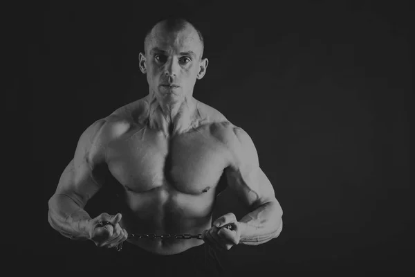 Fisiculturista posando em diferentes poses demonstrando seus músculos. Falha num fundo escuro. Homem mostrando músculos se esforçando. Bonito atleta corpo muscular . — Fotografia de Stock