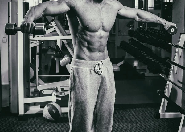 Un hombre muy fuerte se dedica al gimnasio —  Fotos de Stock