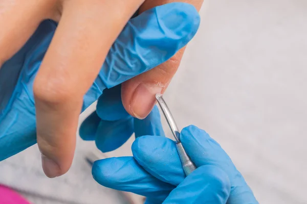 Primo piano di una donna in un salone di bellezza che riceve una manicure da — Foto Stock