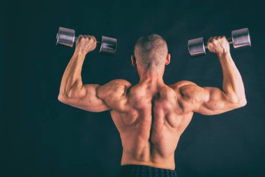 Siyah bir arka plan üzerinde kas, kabartma vücut vücut geliştiricisi. Siyah bir