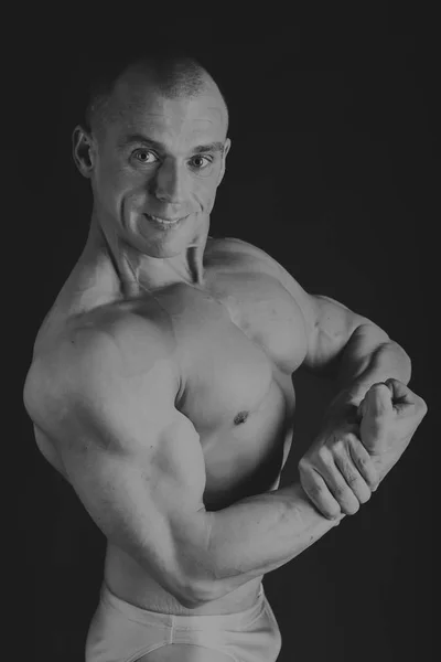 Hombre atlético poder guapo en el entrenamiento bombeo de los músculos con —  Fotos de Stock